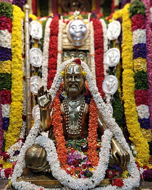 Golden Statue of Sai Baba Adorned with Colorful Flower Garlands and White Jasmine HD phone wallpaper