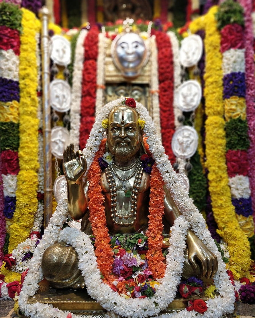 Golden Statue of Sai Baba Adorned with Colorful Flower Garlands and White Jasmine HD phone wallpaper