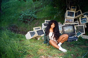 SZA in CTRL album artwork sitting in grass surrounded by old CRT monitors HD wallpaper