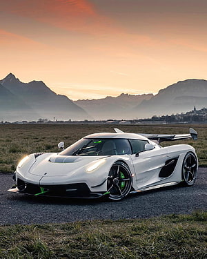 White Koenigsegg Jesko hypercar parked on a rural road at sunset with mountain backdrop HD phone wallpaper