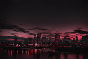 Dramatic Red Tinted City Skyline at Night with Water Reflections HD wallpaper