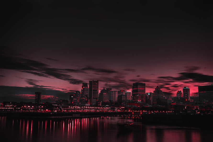 Dramatic Red Tinted City Skyline at Night with Water Reflections HD wallpaper