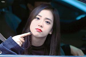 Jisoo from BLACKPINK pointing at her cheek with a playful expression inside a car HD wallpaper