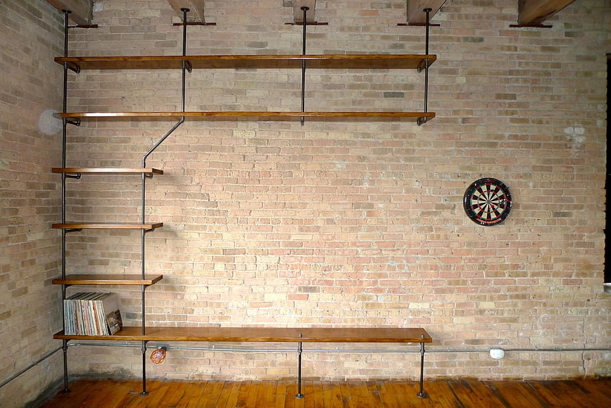 Industrial Loft Interior With Exposed Brick Wall, Pipe Shelving, and Dartboard HD wallpaper