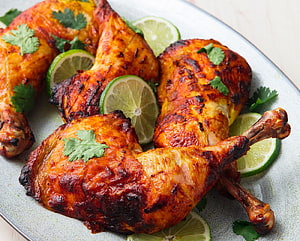 Crispy Tandoori Chicken Legs with Lime Slices and Fresh Cilantro Garnish HD wallpaper