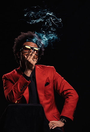The Weeknd in a red suit smoking a cigarette with dramatic blue smoke against a black background HD phone wallpaper