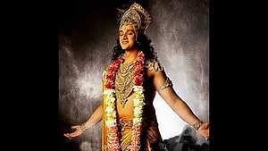 Krishna in ornate traditional attire with floral garlands and elaborate jewelry HD wallpaper
