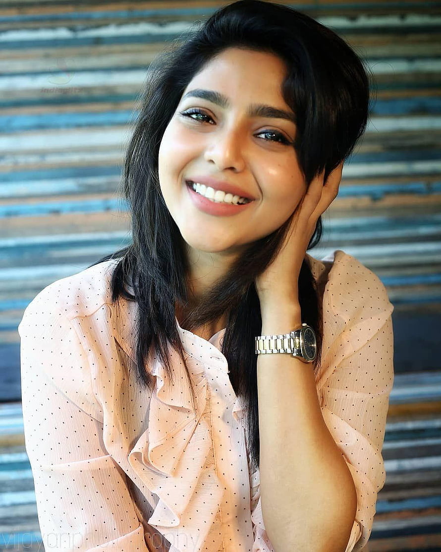 Aishwarya Lekshmi smiling portrait in a peach polka dot blouse with a silver wristwatch HD phone wallpaper