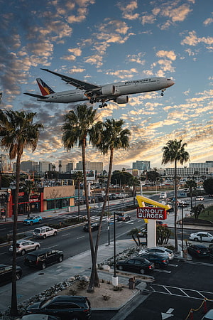 Philippines Airlines plane landing over In-N-Out Burger sign in Los Angeles at sunset HD phone wallpaper