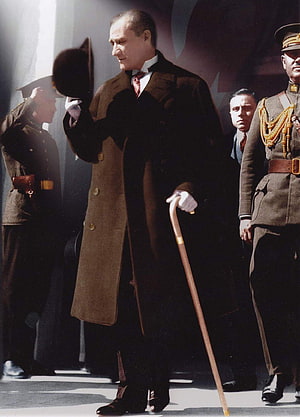 Benito Mussolini in a brown overcoat holding a cane and hat HD phone wallpaper