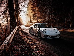 White Porsche 911 GT3 RS on a winding forest road at golden hour HD wallpaper