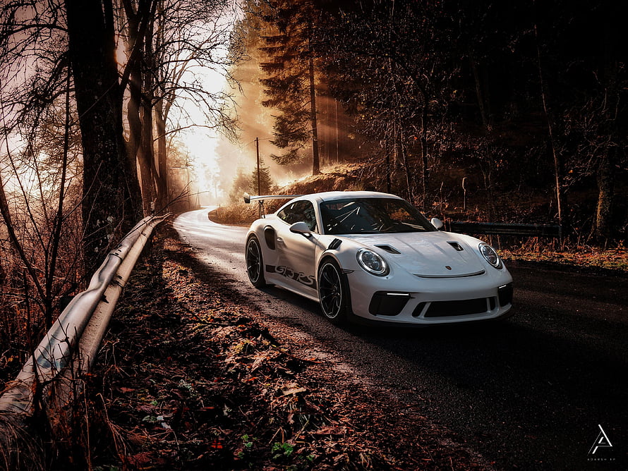 White Porsche 911 GT3 RS on a winding forest road at golden hour HD wallpaper