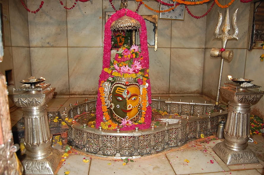 Sacred Ardhanarishvara Shiva Lingam Adorned With Pink Flowers And Silver Trishul In Temple HD wallpaper