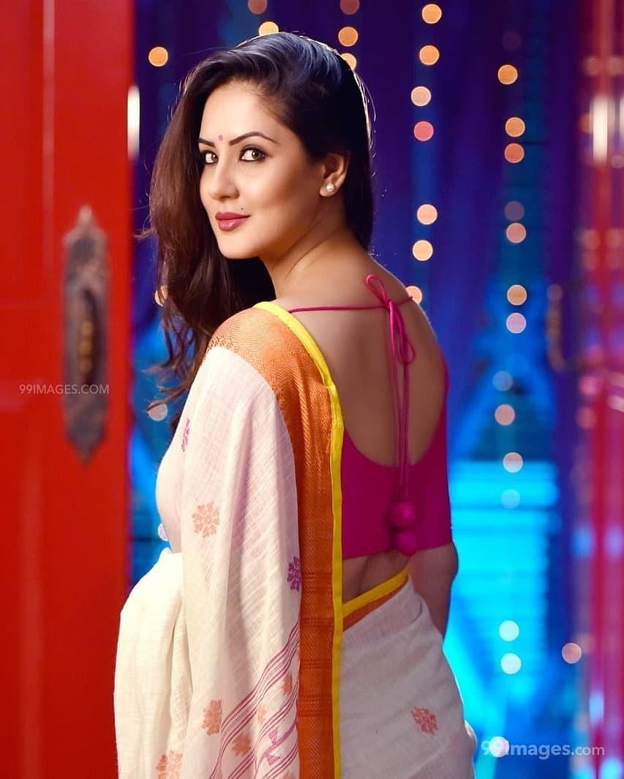 Puja Banerjee in a white and orange saree with a pink blouse against a festive bokeh background HD phone wallpaper