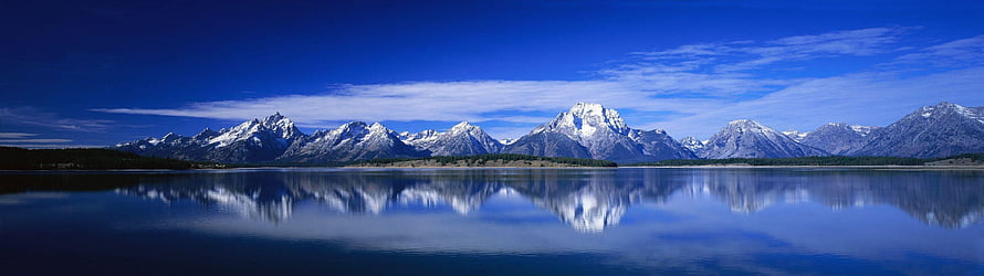 Snow-Capped Mountain Range Reflected in a Calm Alpine Lake Under a Deep Blue Sky HD wallpaper