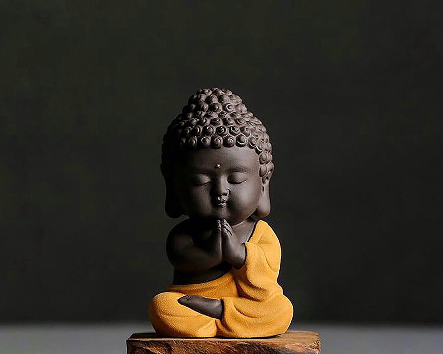 Cute Baby Buddha Statue in Yellow Robe Sitting in Meditation Pose HD wallpaper