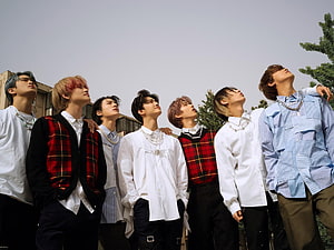 NCT DREAM members in coordinated streetwear posing outdoors under a clear sky HD wallpaper