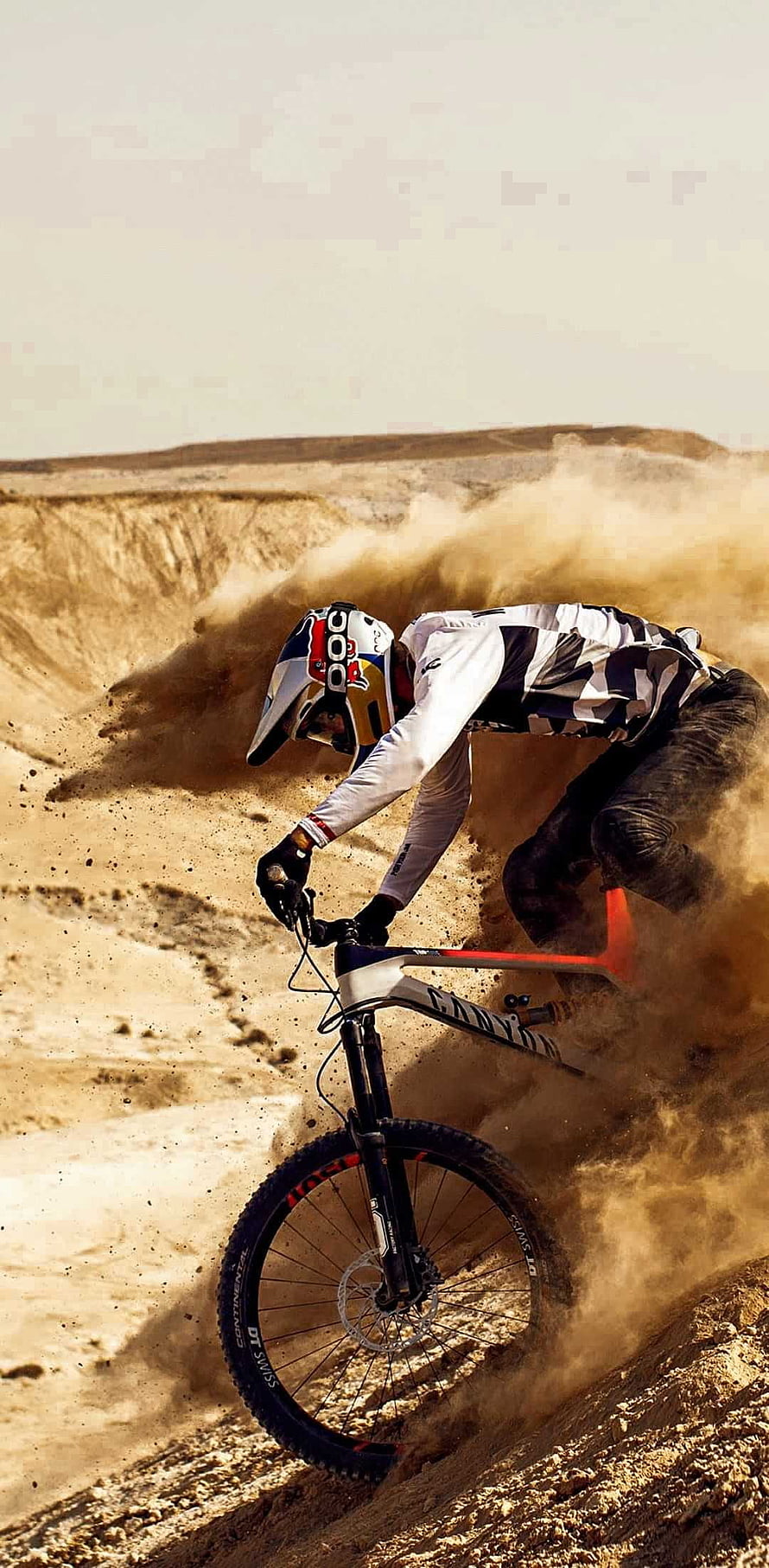 Mountain Biker Carving Through Dusty Desert Trail on a Canyon Bike HD phone wallpaper