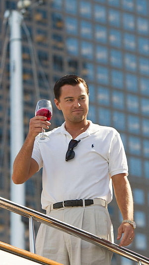 Leonardo DiCaprio as Jay Gatsby holding red wine on a yacht in The Great Gatsby movie scene HD phone wallpaper