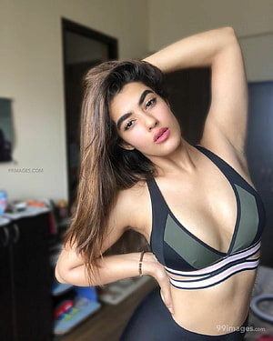Kavya Thapar in a sporty black and green athletic top with a confident indoor pose HD phone wallpaper