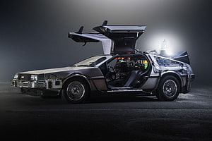 DeLorean DMC-12 Time Machine with Gullwing Doors Open in Dark Studio Setting HD wallpaper