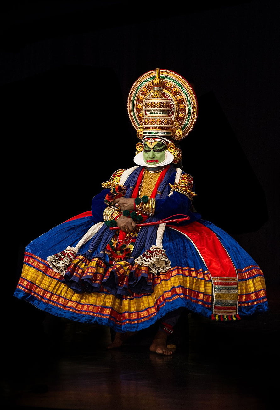 Kathakali dancer in elaborate traditional costume with green face paint and ornate headdress HD phone wallpaper