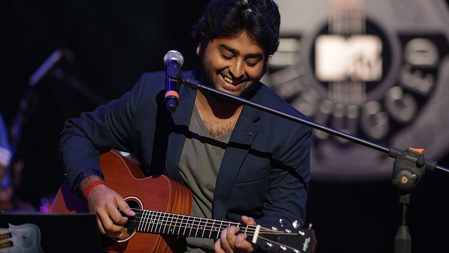 Arijit Singh performing live on stage with acoustic guitar and microphone HD wallpaper