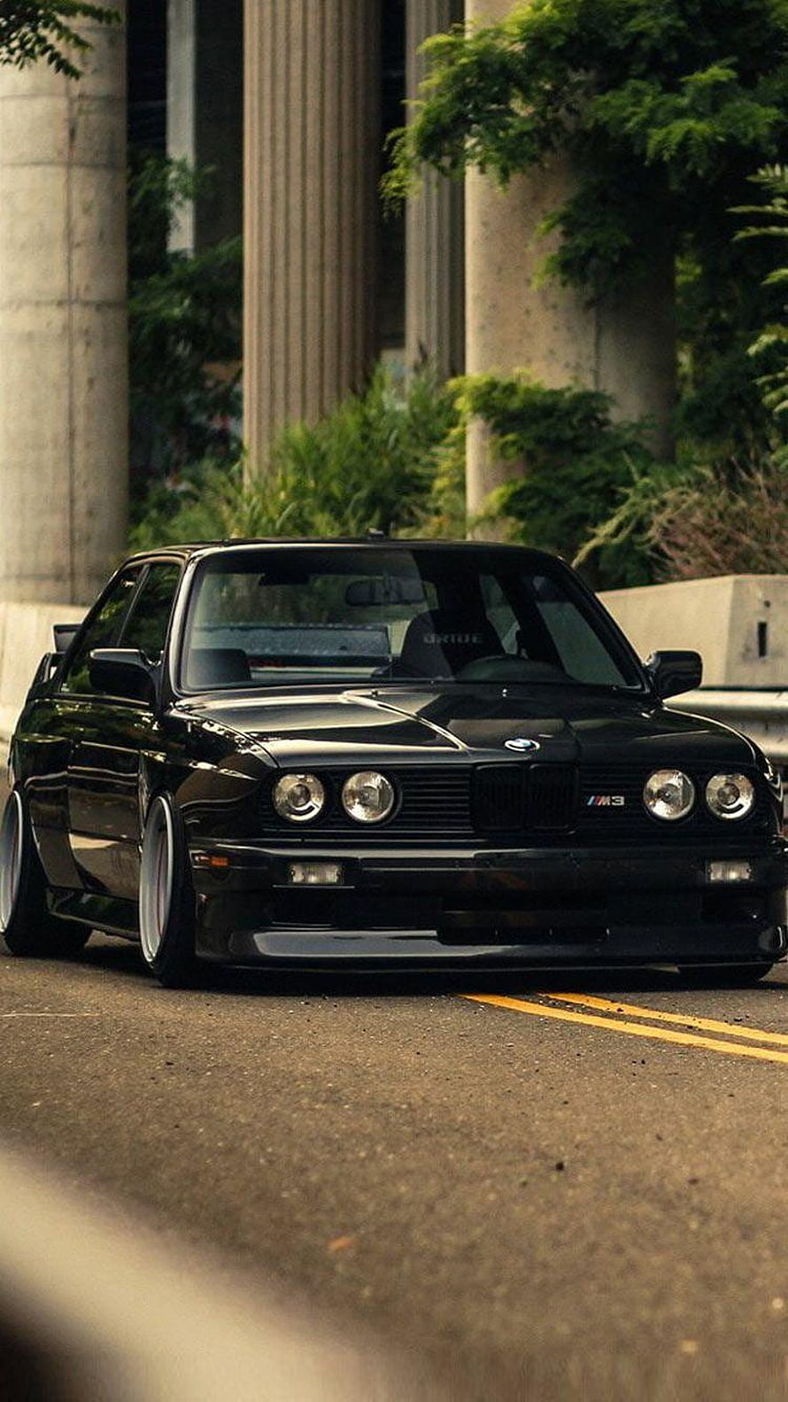 Black BMW E30 M3 Stance Build Parked on Urban Street with Concrete Pillars HD phone wallpaper