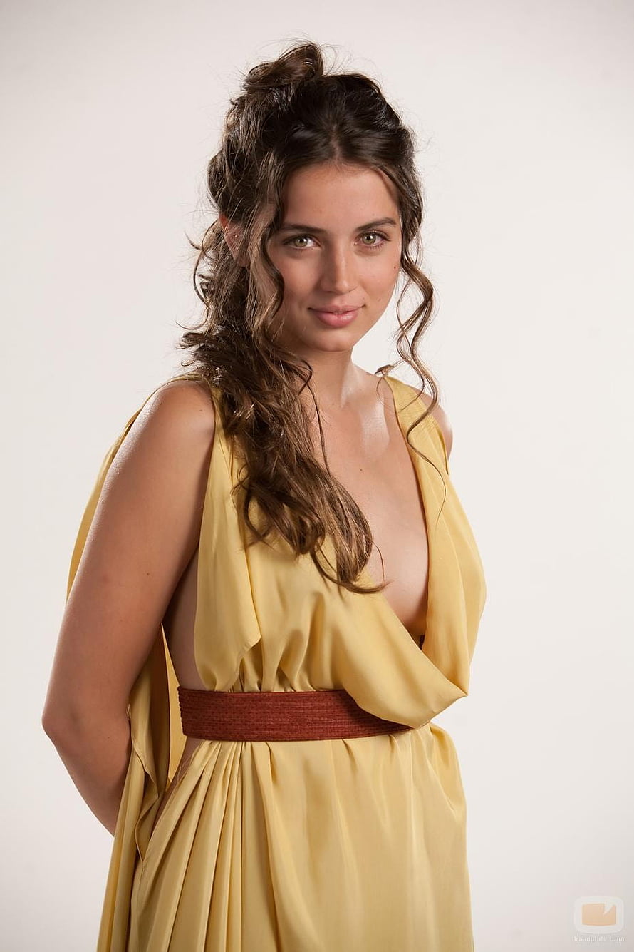 Ana de Armas in a flowing yellow gown with a brown sash and styled wavy hair HD phone wallpaper