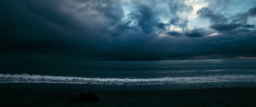 Moody Ocean Horizon Under Dark Storm Clouds at Dusk HD wallpaper