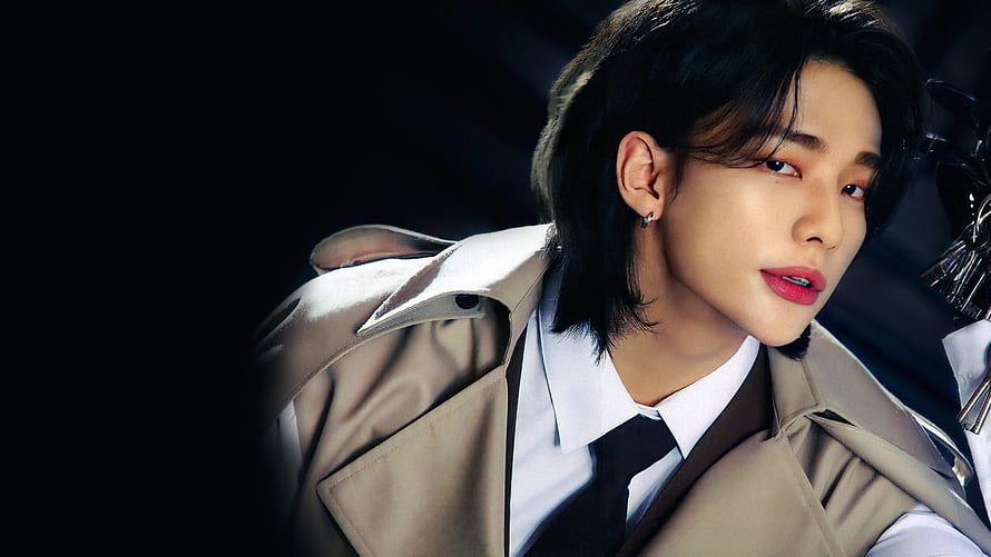 Hwang Hyunjin in a beige trench coat with a white shirt and black tie against a dark background HD wallpaper