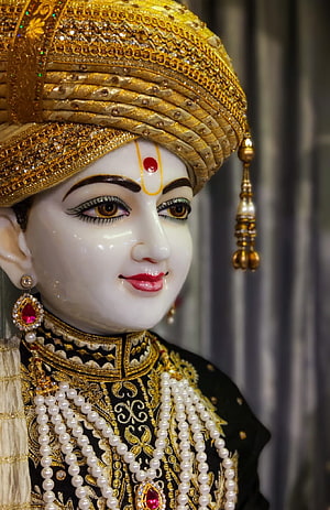 Ornate Swaminarayan Murti with Golden Turban and Pearl Garlands in Temple Setting HD phone wallpaper