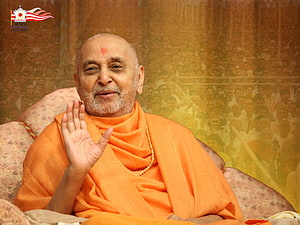 Pramukh Swami Maharaj in Orange Saffron Robes with BAPS Logo and Crowd Background HD wallpaper