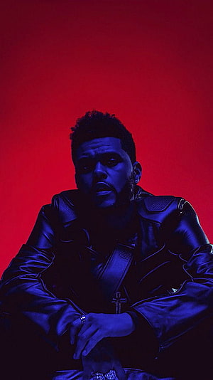 The Weeknd in a black leather jacket with a cross pendant against a vivid red background HD phone wallpaper