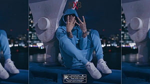 Central Cee in Blue Hoodie Sitting on Bridge at Night with City Lights HD wallpaper