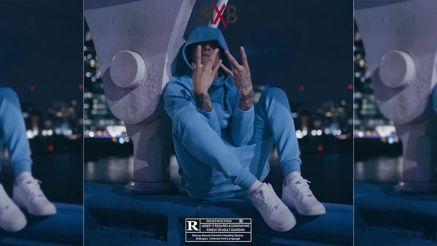 Central Cee in Blue Hoodie Sitting on Bridge at Night with City Lights HD wallpaper