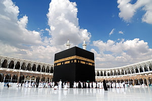 The Kaaba in Mecca Surrounded by Pilgrims Under a Blue Sky HD wallpaper