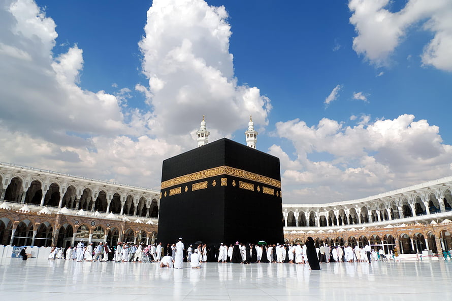The Kaaba in Mecca Surrounded by Pilgrims Under a Blue Sky HD wallpaper