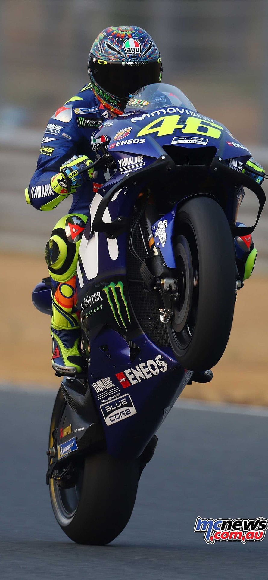Valentino Rossi performing a wheelie on Yamaha MotoGP bike number 46 HD phone wallpaper
