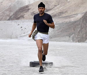Farhan Akhtar as Milkha Singh sprinting across a dusty desert track in Bhaag Milkha Bhaag HD wallpaper