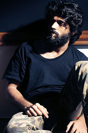 Portrait of a man with a beard and curly hair smoking a cigarette in a black t-shirt, Arjun Reddy, vijay devarakonda beard HD phone wallpaper
