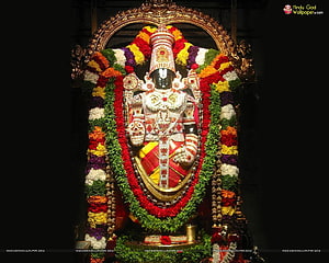 Lord Ayyappa adorned with vibrant flower garlands and traditional jewelry in a temple shrine HD wallpaper
