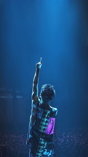 Taka from ONE OK ROCK performing on stage with raised arm under blue concert lighting HD phone wallpaper