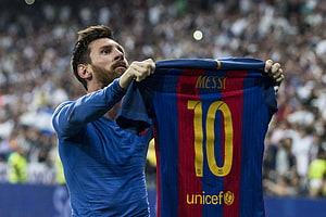 Lionel Messi holding up his FC Barcelona number 10 jersey in front of a stadium crowd HD wallpaper
