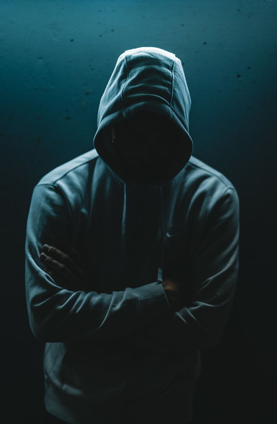 Mysterious Hooded Figure With Arms Crossed In Dark Teal Lighting HD phone wallpaper