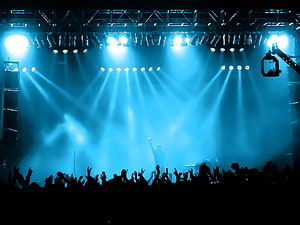 Vibrant Blue Concert Stage With Dramatic Lighting Beams And Silhouetted Crowd HD wallpaper
