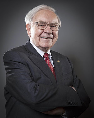 Portrait of Warren Buffett in a dark suit with arms crossed against a grey background HD phone wallpaper