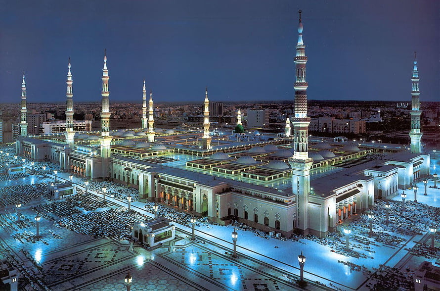 Al-Masjid an-Nabawi in Medina at Night with Illuminated Minarets and Crowds HD wallpaper