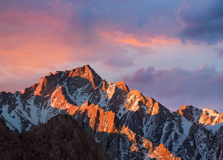 Majestic Snow-Capped Mountain Peaks Bathed in Golden Sunset Light with Pink Clouds HD wallpaper