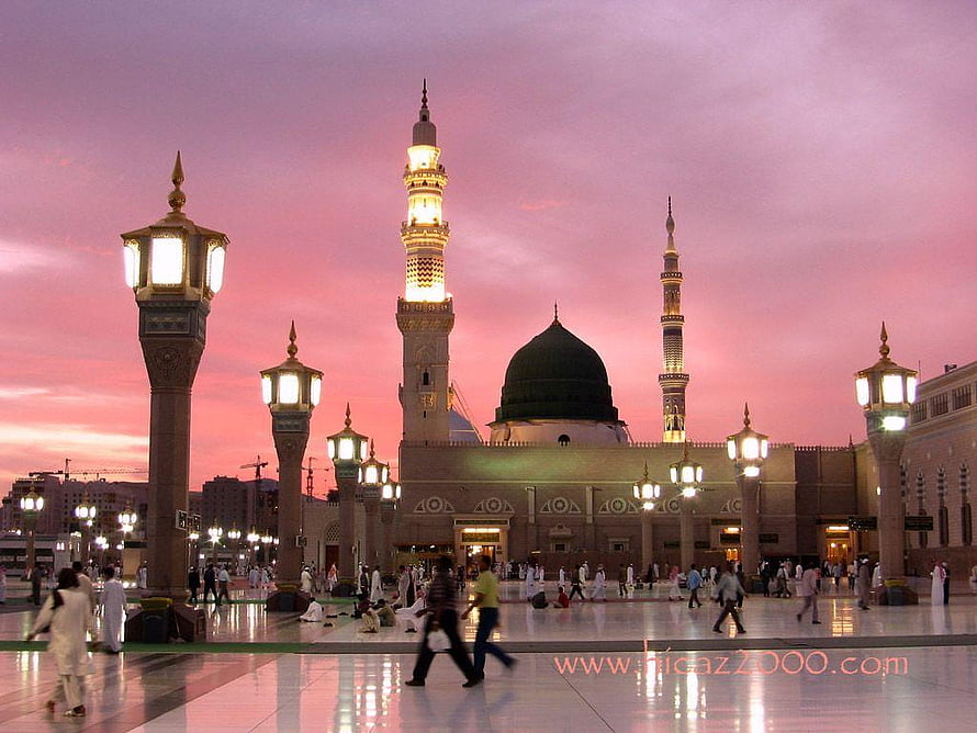 Masjid an-Nabawi in Madinah at sunset with illuminated minarets and green dome HD wallpaper